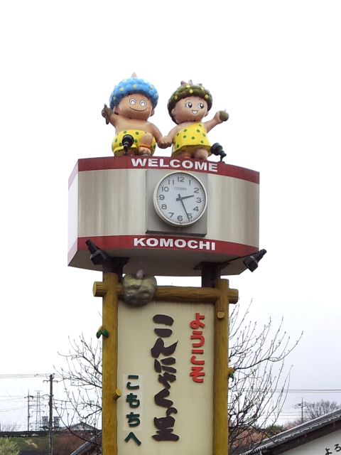 Standing together on the top of a clock tower with ball-shaped konjac on their hands.